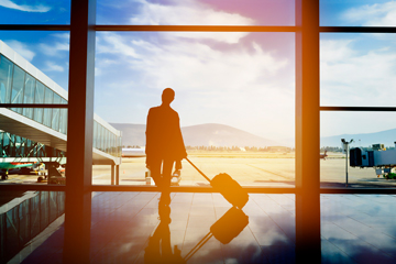 silhouette of person with luggage at airport