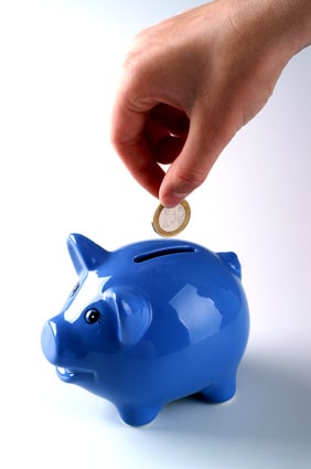 Money being put into a blue piggy bank
