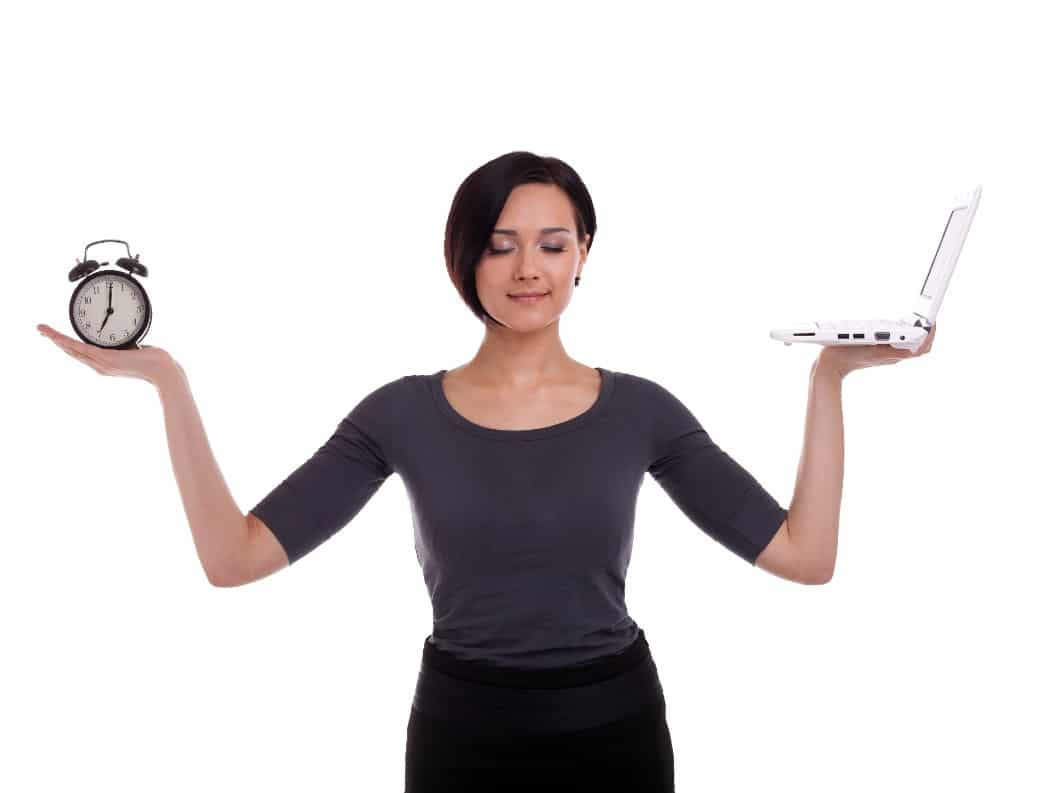 woman holding a clock and laptop