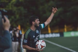 Man playing soccer devising a strategy as he throws the ball in