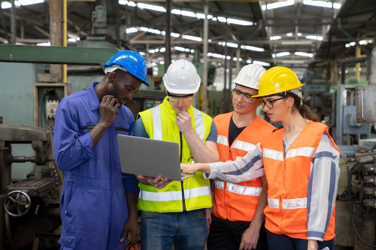 factory workers looking at a laptop