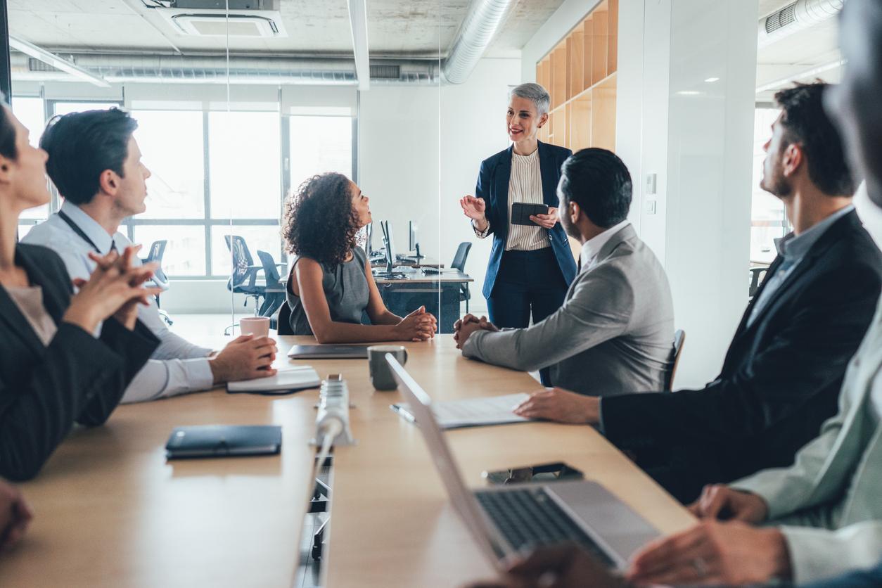 leader giving presentation in front of group in office