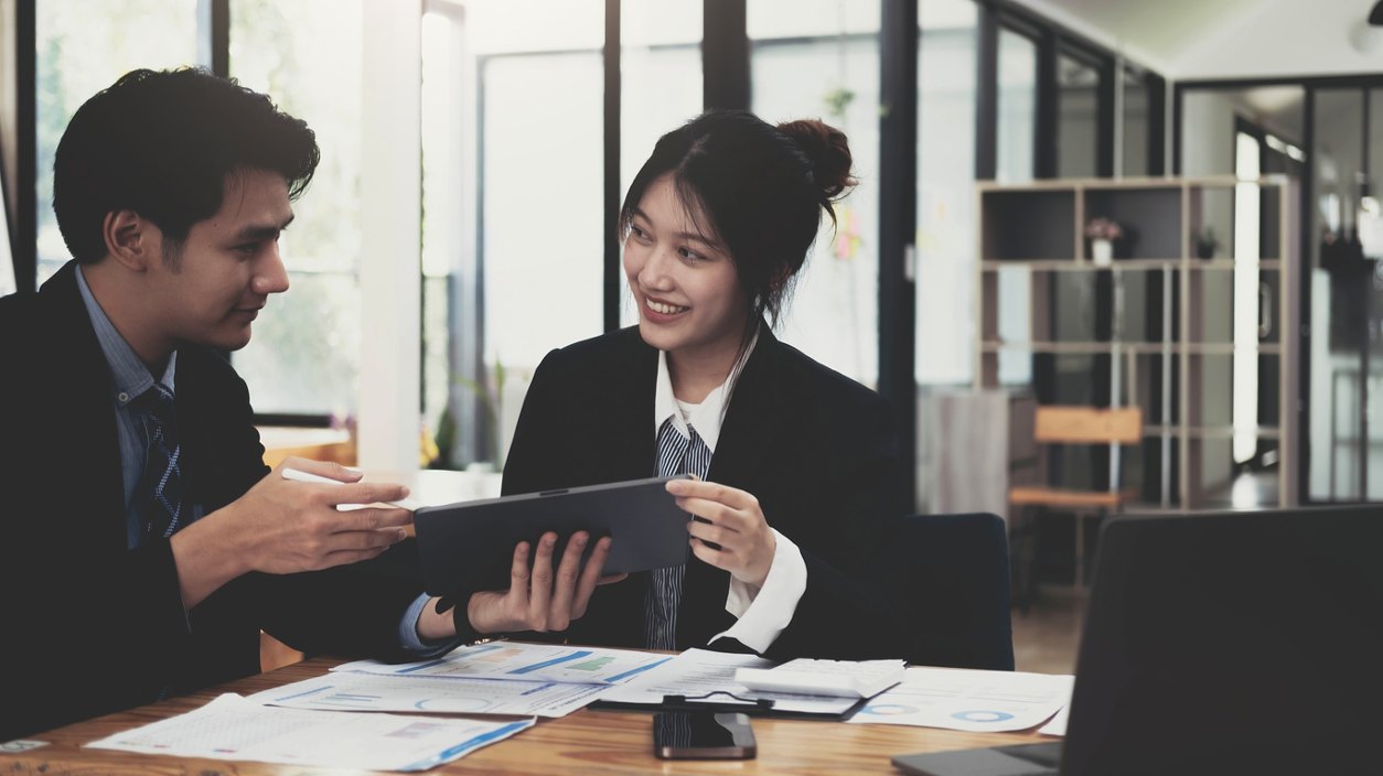 two coworkers reviewing notebook