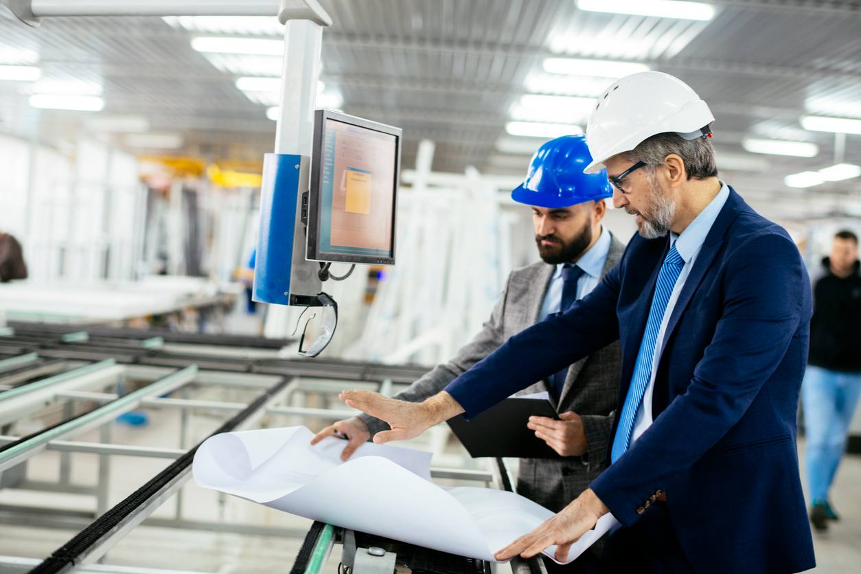two businessmen in a manufacturing plant