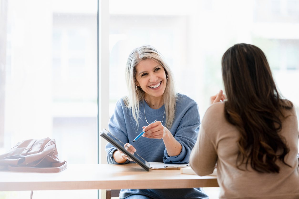 manager meeting with employee pointing at tablet to discuss performance