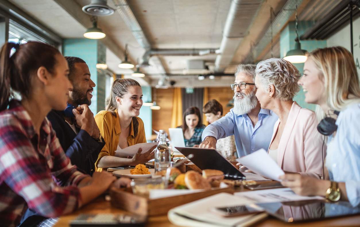 business people gathered around a table smiling