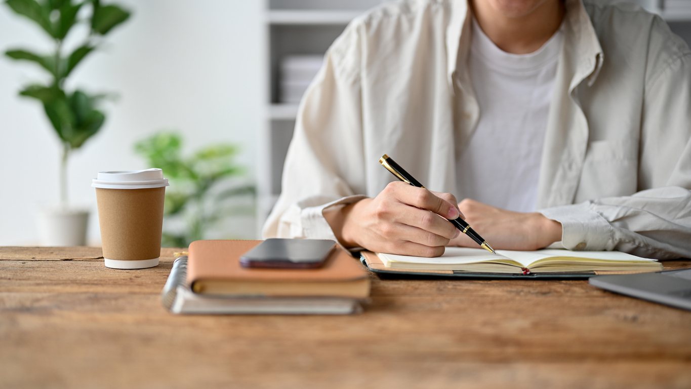 close up of person writing in a notebook