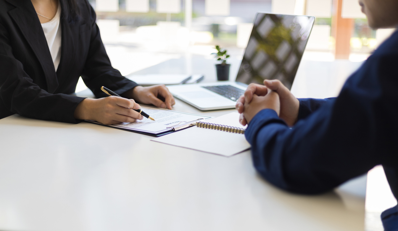 close up of two business people writing on clipboard