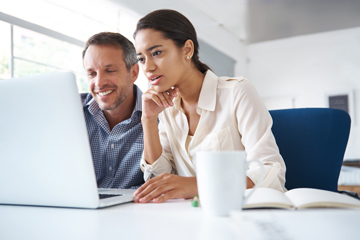 woman and her coworker looking at a laptop