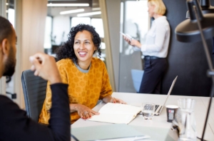 woman smiling in office with people in background