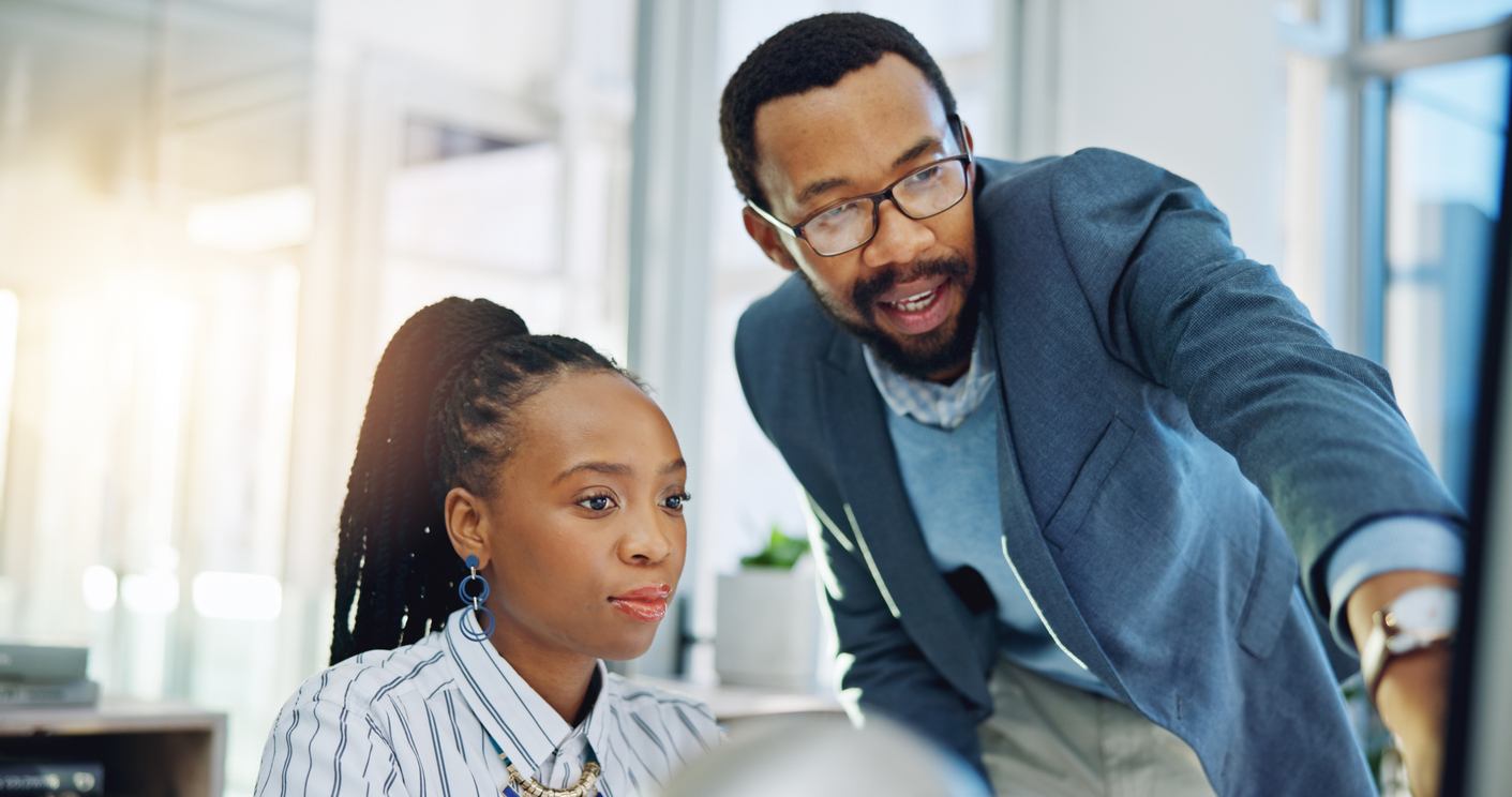 boss giving employee feedback pointing at her computer