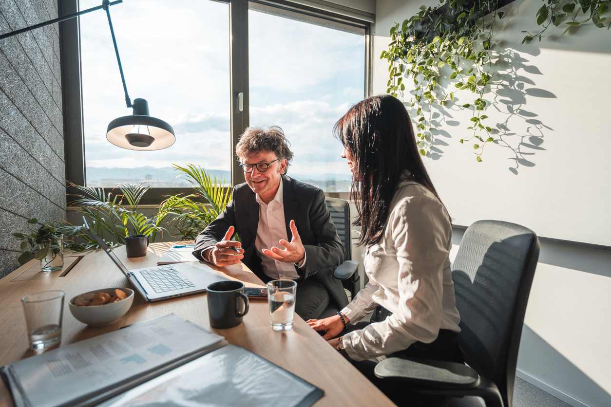 Mature Male CEO Working With A Young Female Financial Advisor stock photo