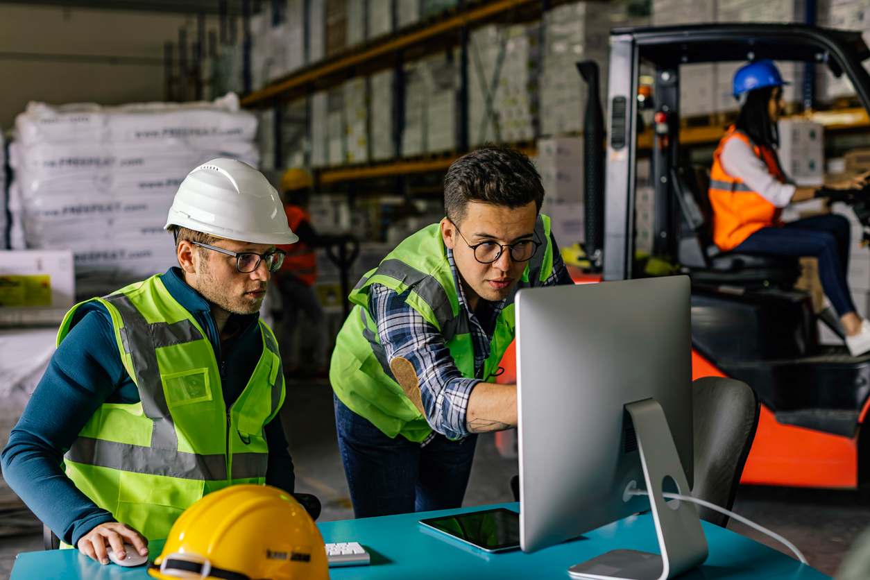 plant manager and employee looking at desktop