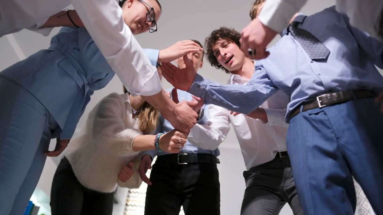 team joining hands in middle