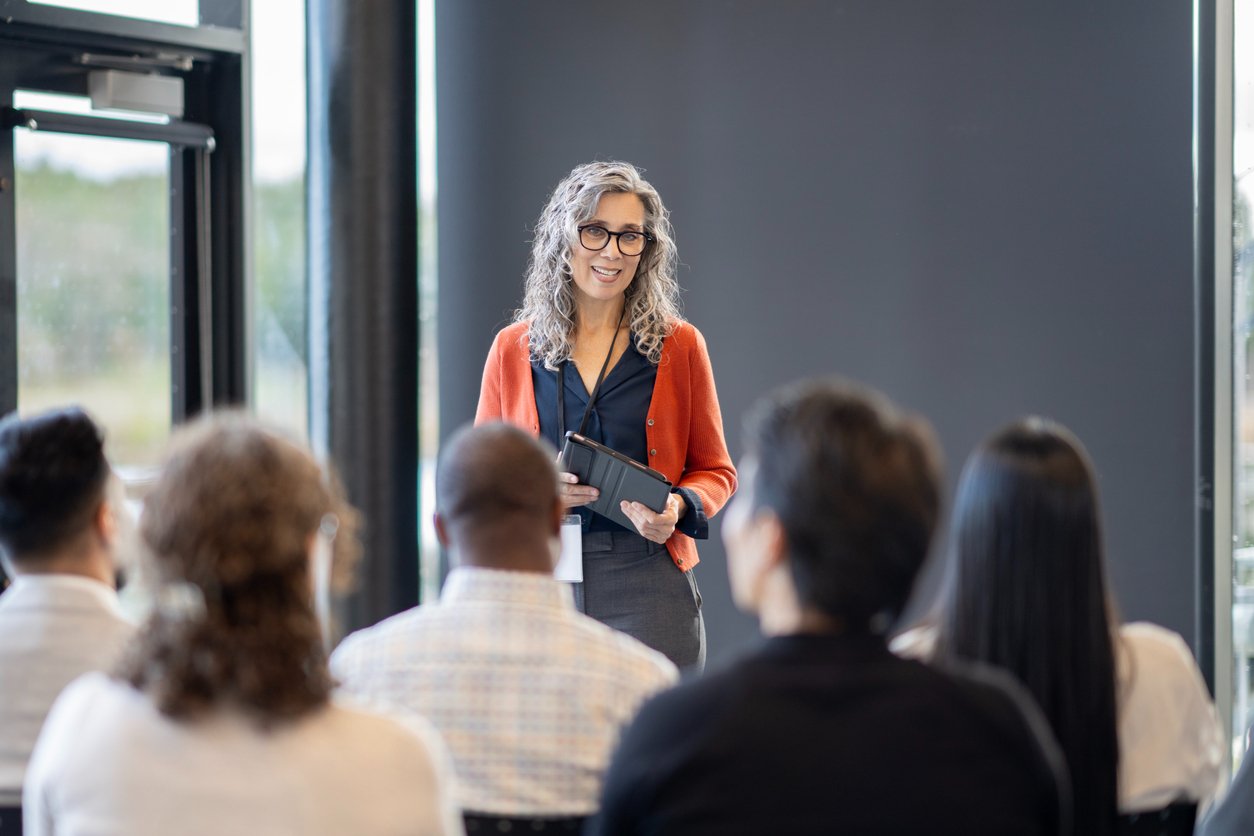 delivering a presentation to work colleagues inside a boardroom