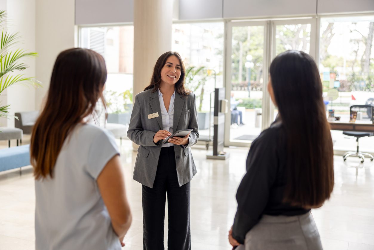 Hotel manager talking to a couple of employees at the lobby stock photo