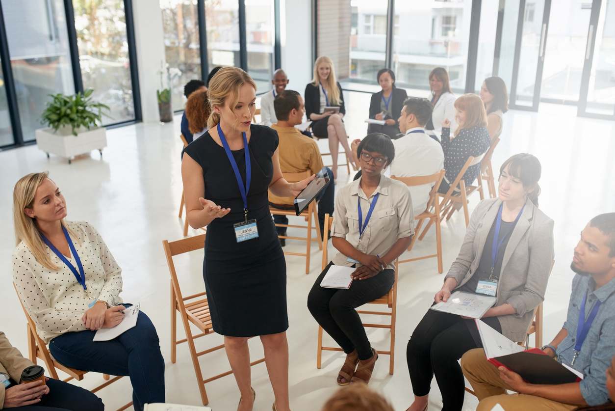 iStock-1155374981 business woman standing in group speaking